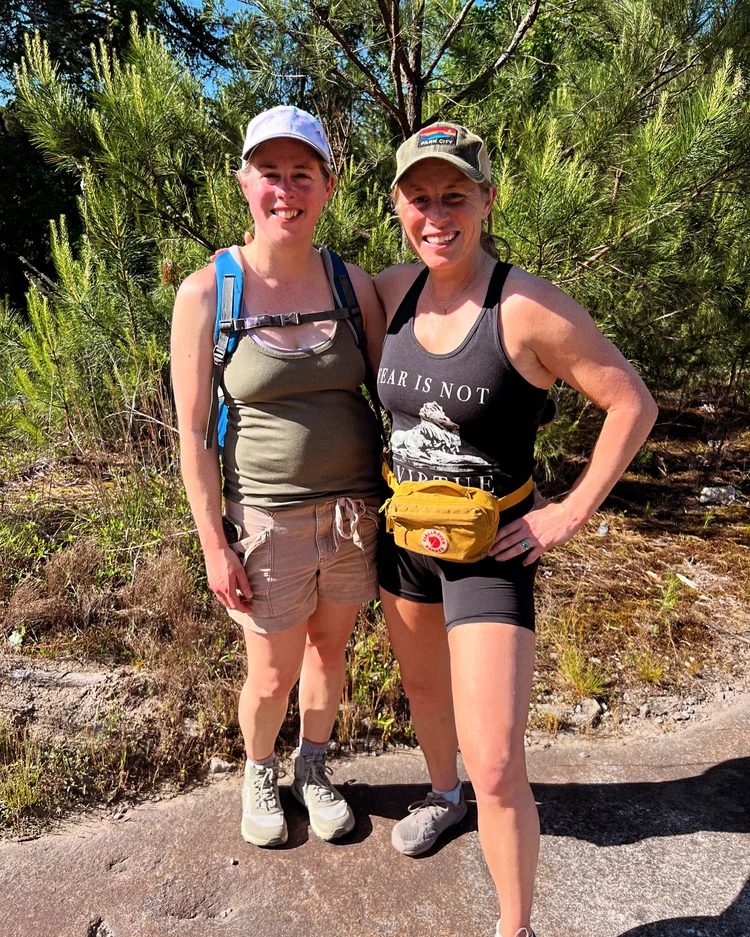 Two women smiling outdoors after a hike
